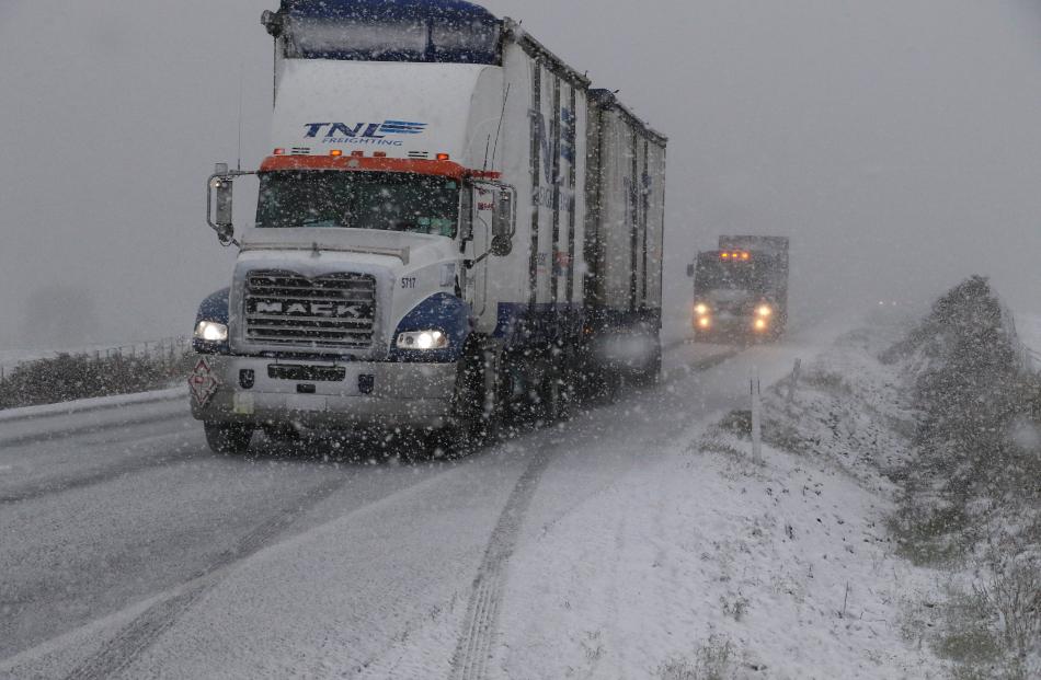 Tuesday morning and trucks and cars slowly navigate SH1 at Milburn during one of the snow falls, their way south was soon hampered by dicey road conditions around the Hillend area on Tuesday morning. PHOTO: JOHN COSGROVE