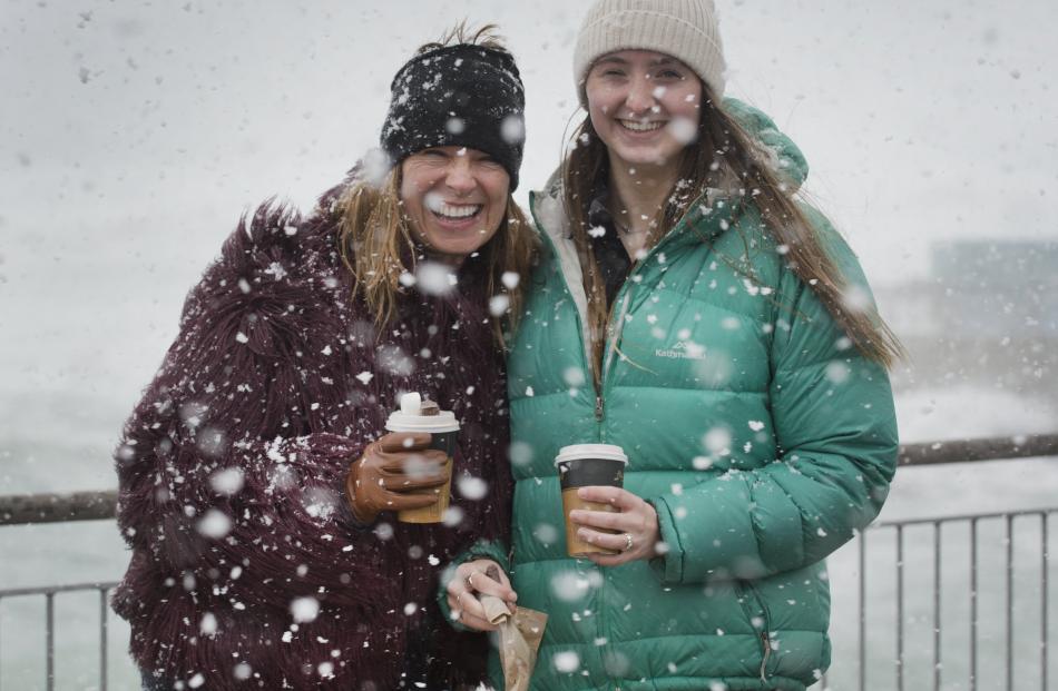 Amanda (left) and Temple Flaws take a stroll on the Esplanade at St Clair during a snow flurry...