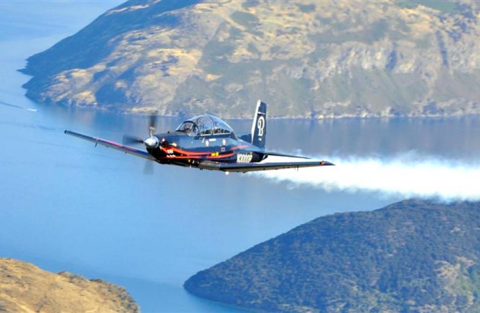 A Hawker Beechcraft LLC T-6C Texan II takes to the air over Lake Wanaka as part of the Warbirds...