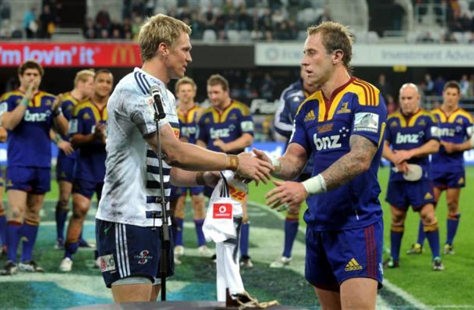 Stormers captain Jean de Villiers makes a presentation to Highlanders halfback Jimmy Cowan. Cowan...