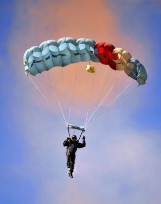 A member of the RNZAF's Kiwi Blue parachute team readys to land during Warbirds over Wanaka on...
