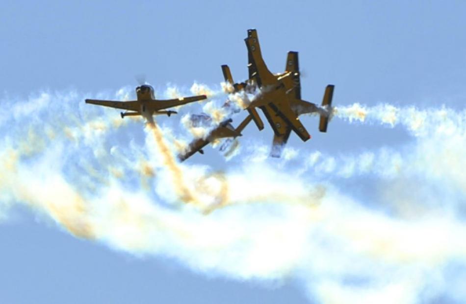 Aircraft from the RNZAF's Red Checkers perform a Spaghetti Break maneuver during Warbirds over...