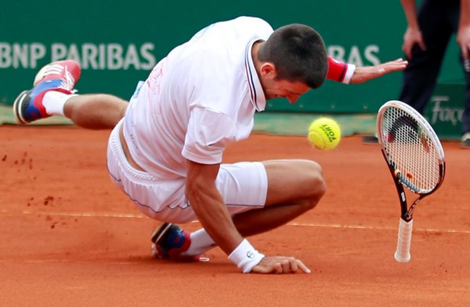 Novak Djokovic of Serbia falls during his match against Andreas Seppi of Italy during the Monte...