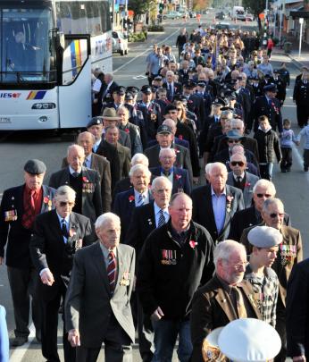 Returned servicemen march down Gordon Road before yesterday's Anzac Day service in Mosgiel.