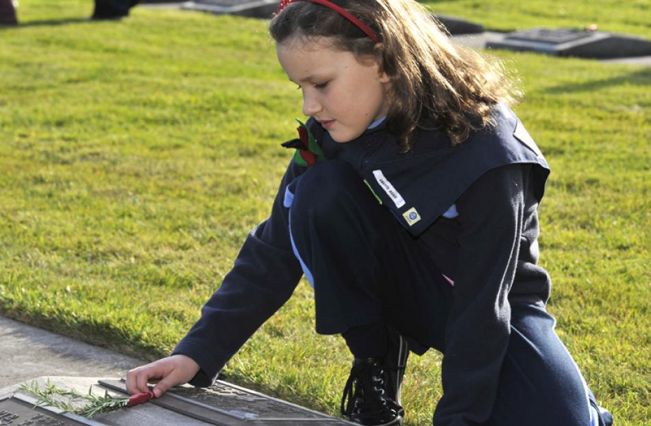 Sophie Wispinski (8), from Grants Braes Brownies, lays a posie on a soldiers grave at the...