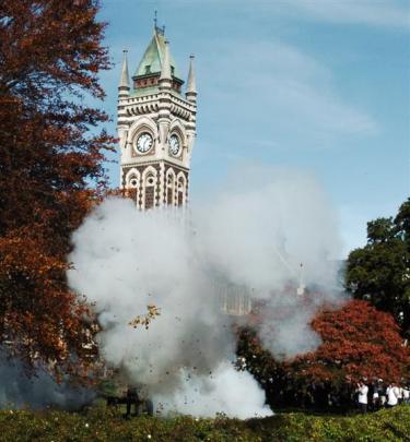 Smoke rises from  a two-gun salute to start the service.