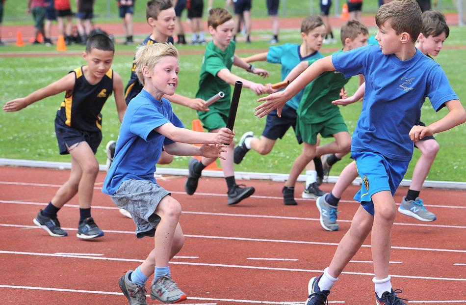 Jimmy Hinds passes the baton to Reuben Ure (both 9) for the Macandrew Bay School team in the boys...