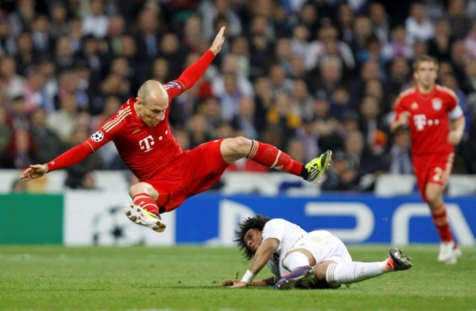 Bayern Munich's Arjen Robben (L) falls over Real Madrid's Marcelo during their Champions League...