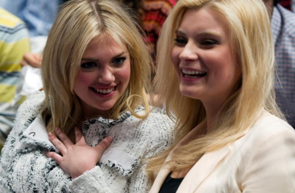 Sports Illustrated swimsuit model Kate Upton (L) sits with a friend as they watch the New York...