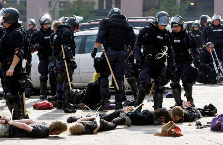 Police watch over a group of people who were arrested after a protest during the Republican...