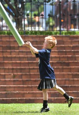 Max Collins (8), of Dunedin, throws a plastic caber during the celebrations.