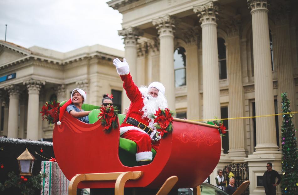 Santa Claus and his helpers make their way past the crowds at the Oamaru Christmas parade...