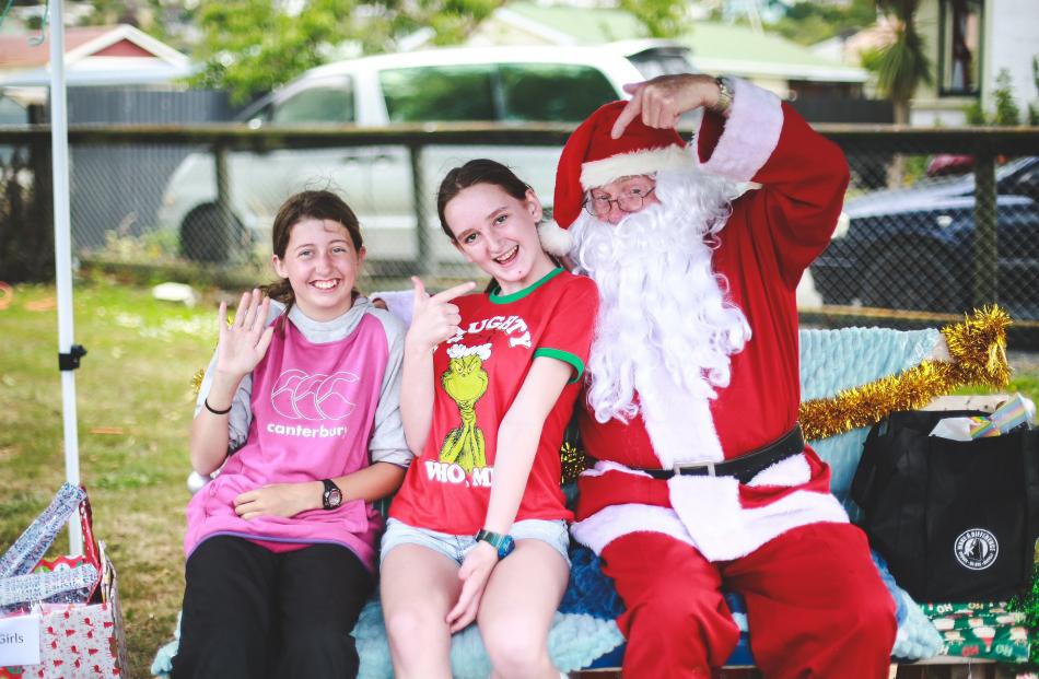 Jacquie Sinclair (left) and Mercedes Kennedy (both 13) pose for a photo with Santa Claus.