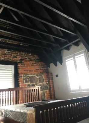 Exposed brick and timber vaulted ceilings feature in rooms at The Stables.

