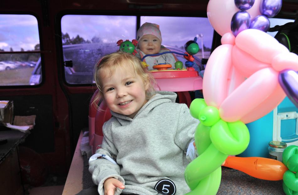 Tori (3) and Emily  (10 months) Glennie, play with balloons as they shelter from the rain.