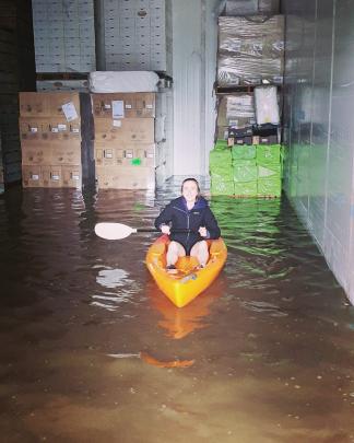 Panmure Orchards packhouse manager Jacqui Beer kayaks in a flooded shed at the Earnscleugh...
