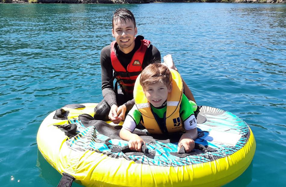 Bryn (21) and Fletcher (8) Hill enjoy some biscuiting on a calm, sunny day on Lake Benmore, on...