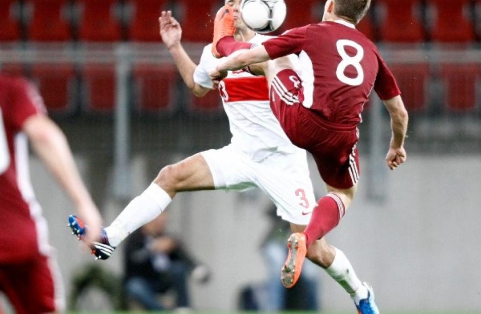 Poland's Grzegorz Wojtkowiak (L) and Latvia's Aleksandrs Cauna fight for the ball during their...
