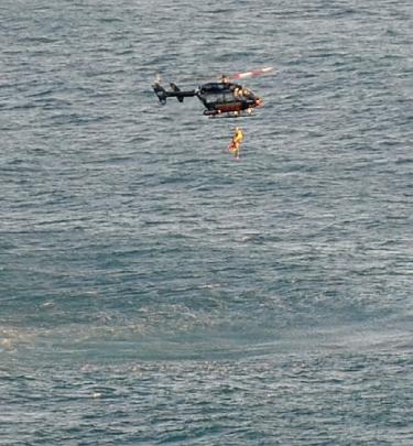 A fisherman is winched into the helicopter. Photos by Peter McIntosh and Otago Regional Rescue...
