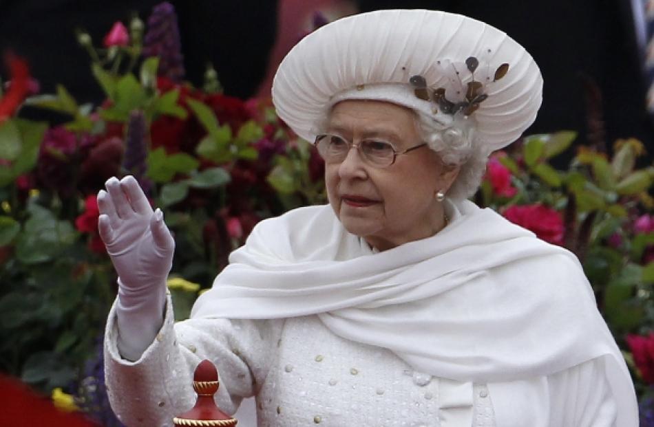 Britain's Queen Elizabeth waves from onboard the Spirit of Chartwell, as it approaches...