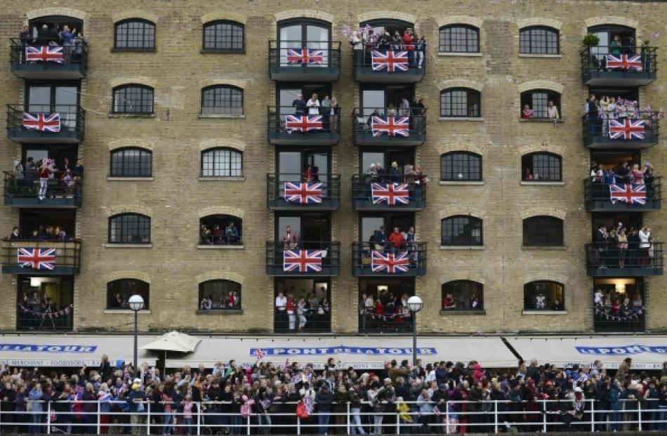 Spectators watch a pageant along the River Thames near Tower Bridge, in celebration of the Queen...