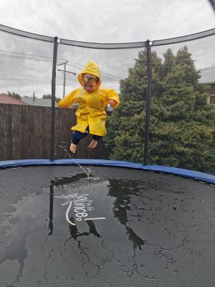 Oliver McHoull (3) did not let the wet Dunedin weather stop him enjoying his Christmas present...