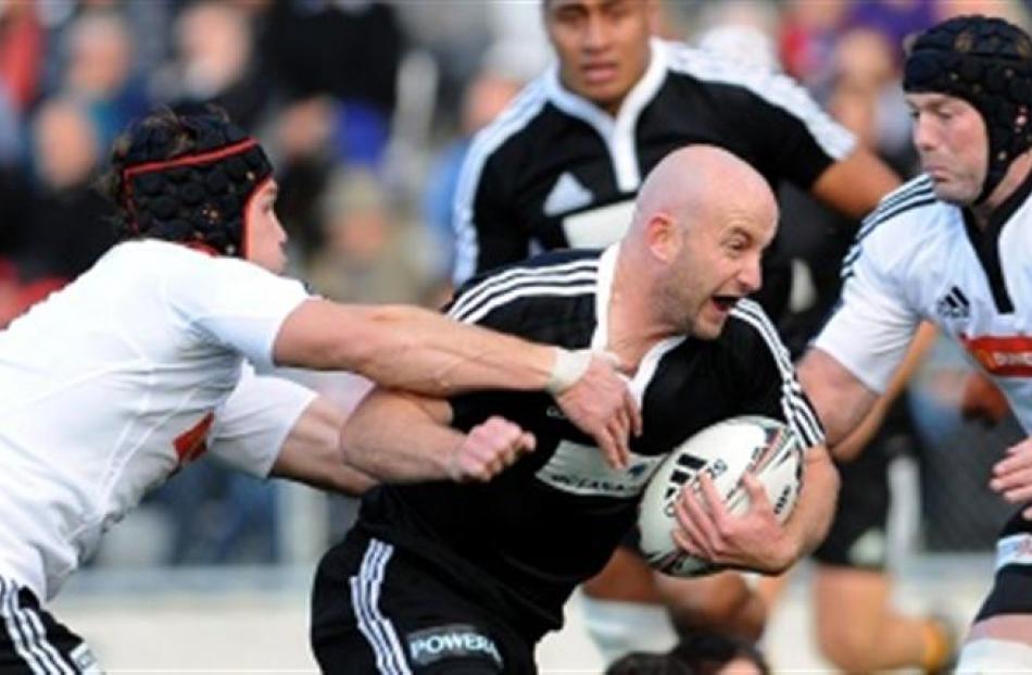 North Island halfback Brendon Leonard tries to barge through the South Island defence of Matt...