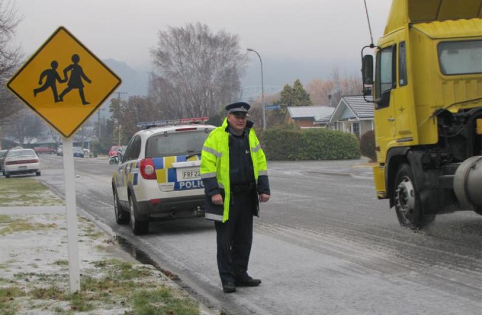 Senior Constable Mike Colligan keeps an eye on well-behaved drivers in the icy conditions in...