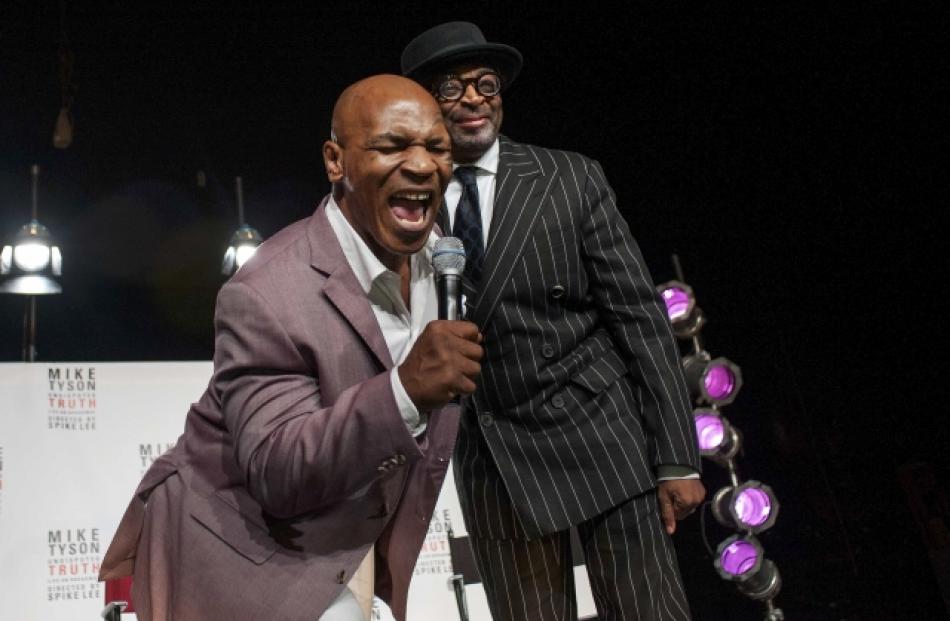 Spike Lee (R) watches as former heavyweight champion Mike Tyson sings during a news conference...