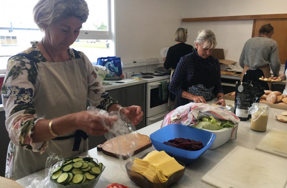 Ainsley Burton (left) and Francie Winter were part of a team of volunteers preparing lunch for...