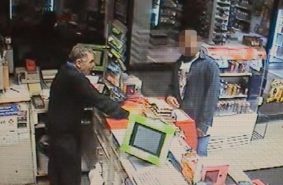 The man (right) who allegedly stole the car is captured on the service station's security camera....