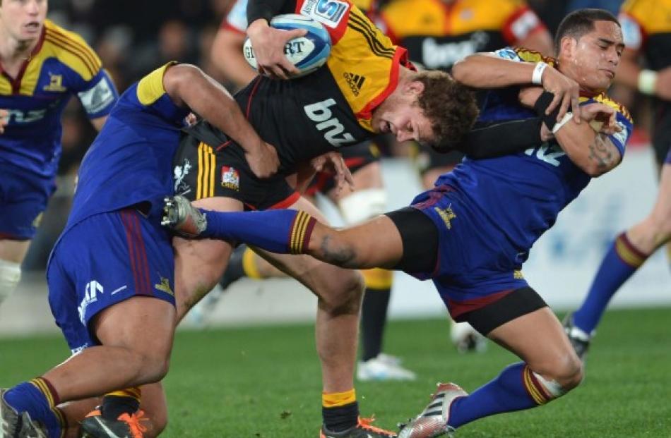 Chiefs halfback Tawera Kerr-Barlow tries to bust through the Highlanders defence.