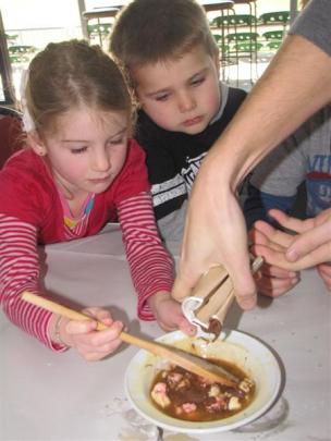 Keeping a close eye on the addition of chocolate to their rice-bubble cake mixture are Katharine ...