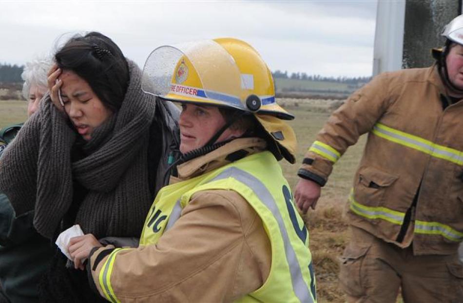 A Chinese tourist is assisted by a firefighter.