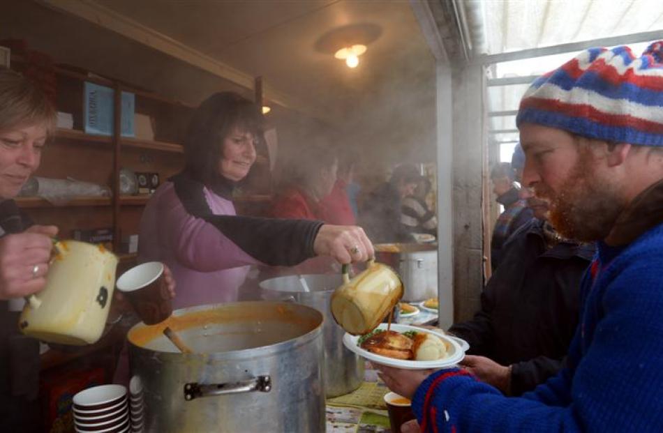 Julie Pyle (left) and Dianne Gillespie, both of Oturehua, serve hot food to    Vaughan Dowling,...