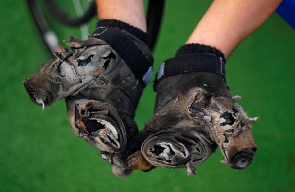 Salvadorean paralympic wheelchair racer Luis Morales shows his gloves after a training session at...