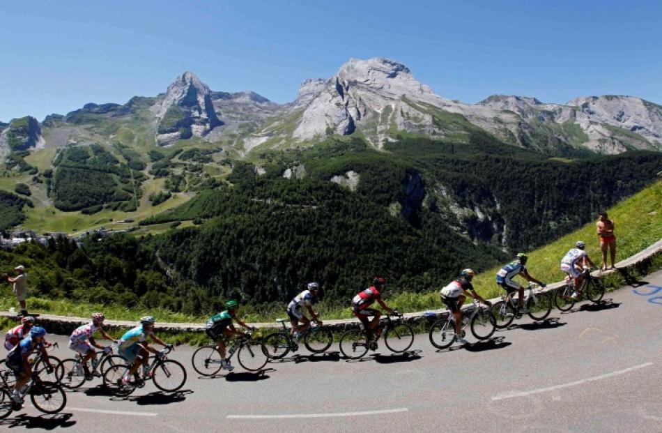 The pack rides in the Pyrenees mountains during the 16th stage of the Tour de France between Pau...