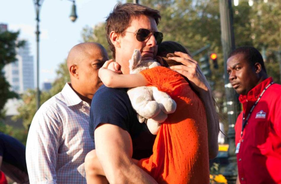 Actor Tom Cruise carries his daughter Suri into the Chelsea Piers sports facility in New York....