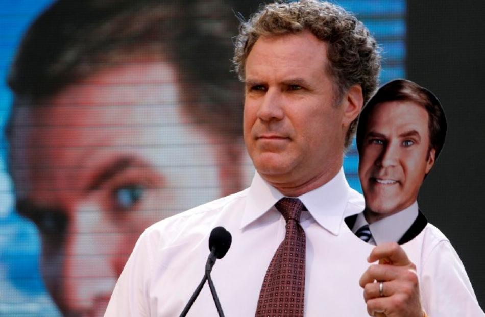 Actor Will Ferrell holds a cutout placard of his face during a mock 'whistle stop tour' press...
