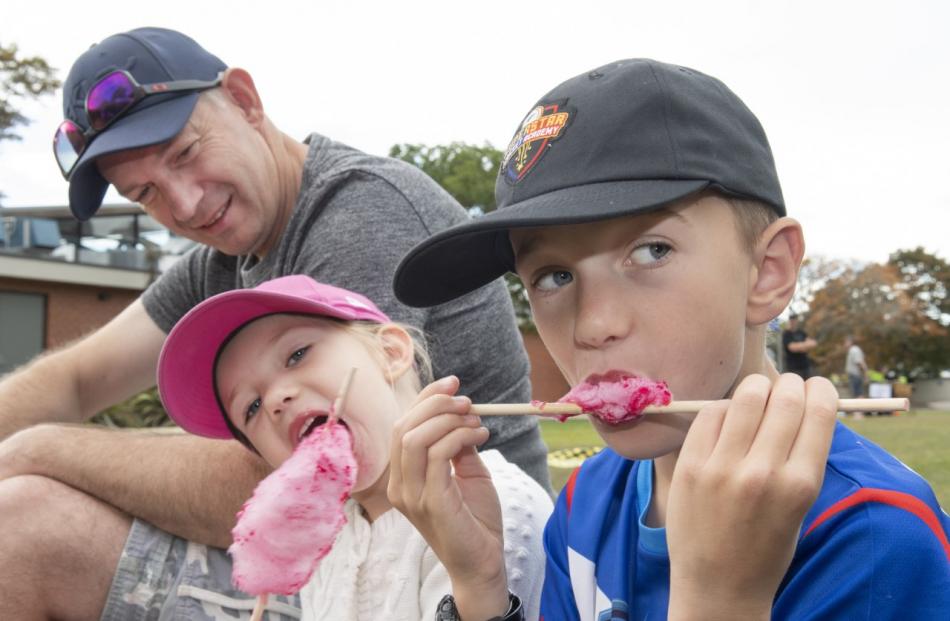 Richard Clark watches his children Isobelle, 4, and Jack, 9, devour candy floss.