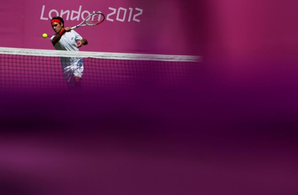Switzerland's Roger Federer returns the ball during an Olympics training session at the All...