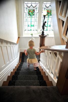 Harper Simms (3) descends the stairs, passing stained glass windows that used to be in an old...