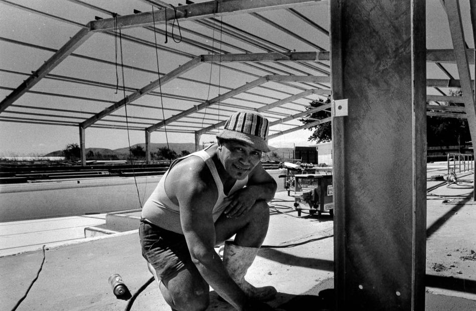 Site foreman Peter Penita puts the finishing touches on the concrete work for the roof at the...