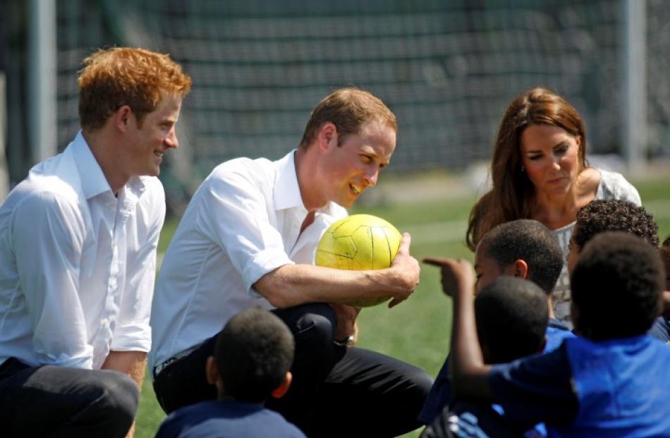 Britain's Catherine (R), Duchess of Cambridge and Prince Harry look on as Prince William (C)...