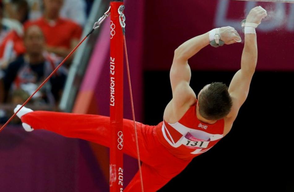 Sam Oldham of Britain falls from the horizontal bar during the men's gymnastics team final.