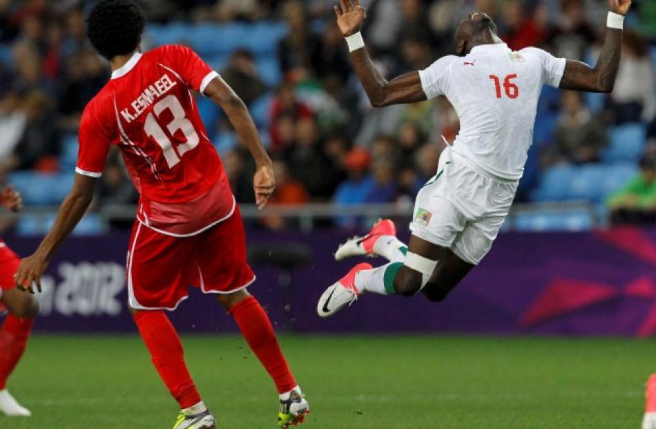 Senegal's Pape Souare (R) falls next to UAE's Khamis Esmaeel during their men's Group A football...