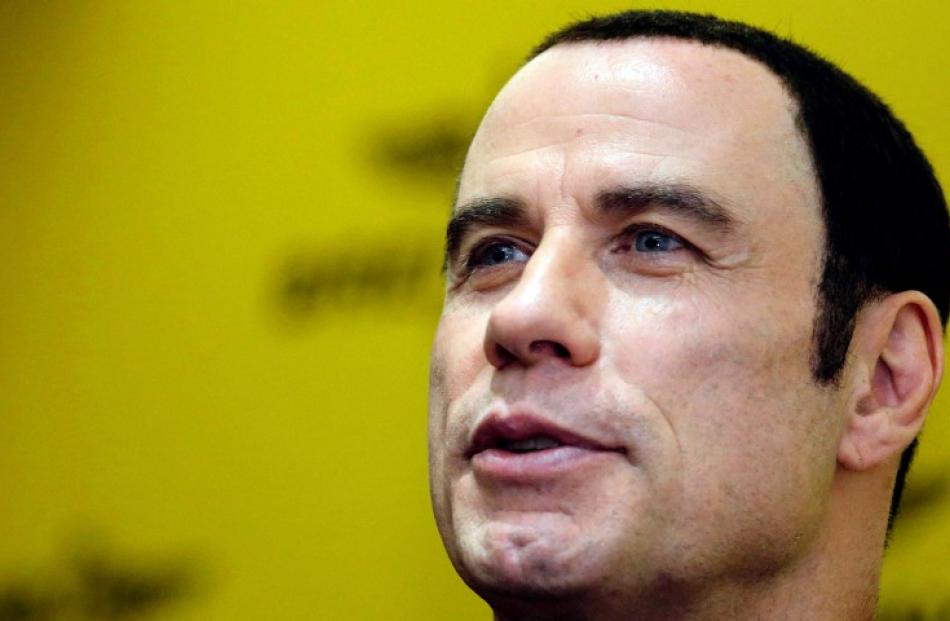 Actor John Travolta speaks during a news conference in Singapore. REUTERS/Tim Chong