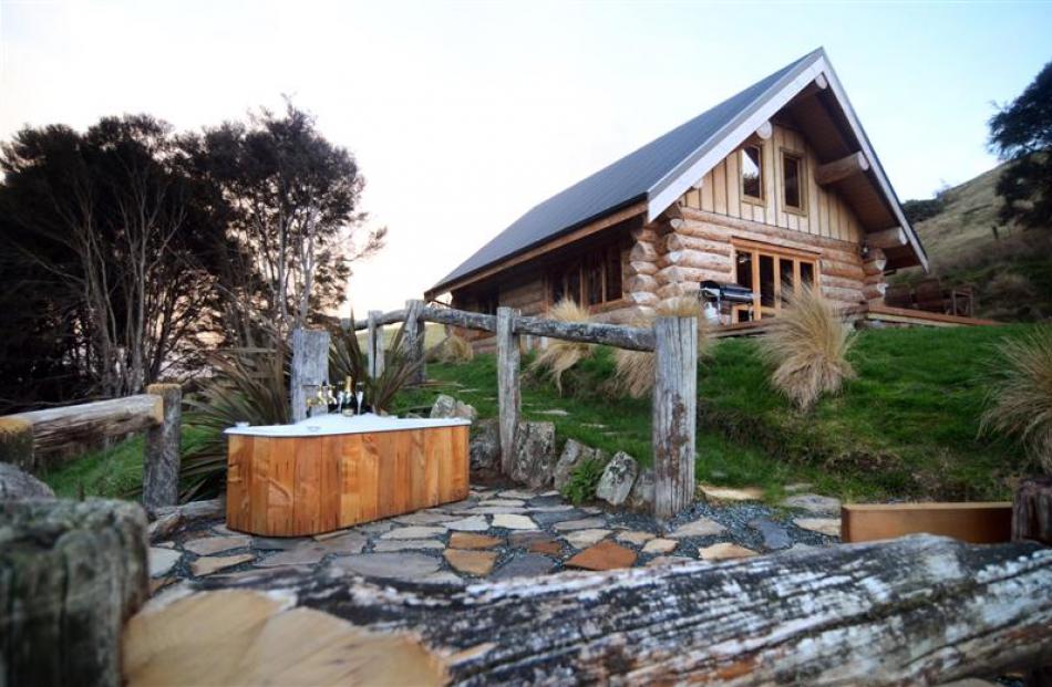 The log cabin, complete with outdoor bath, built by Dave and Janene Divers on their property near...