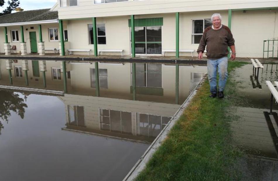 Green supervisor Tim Nichols contemplates the flooded grounds of the Maheno Bowling Club...