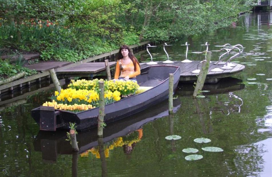 A visitor poses in a boat moored in Keukenhof's canal.